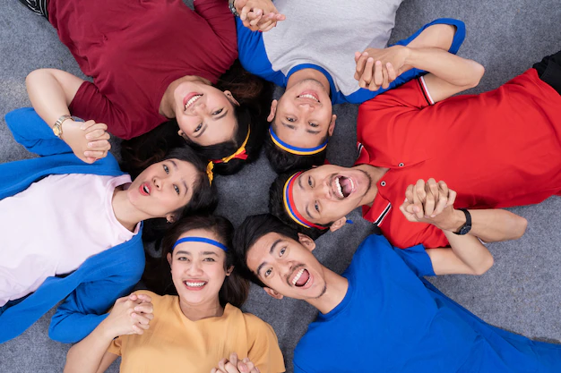 People lying in circle and look at camera