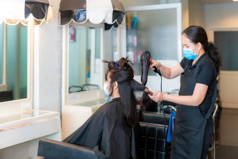 A woman is doing her hair cut at a barber store